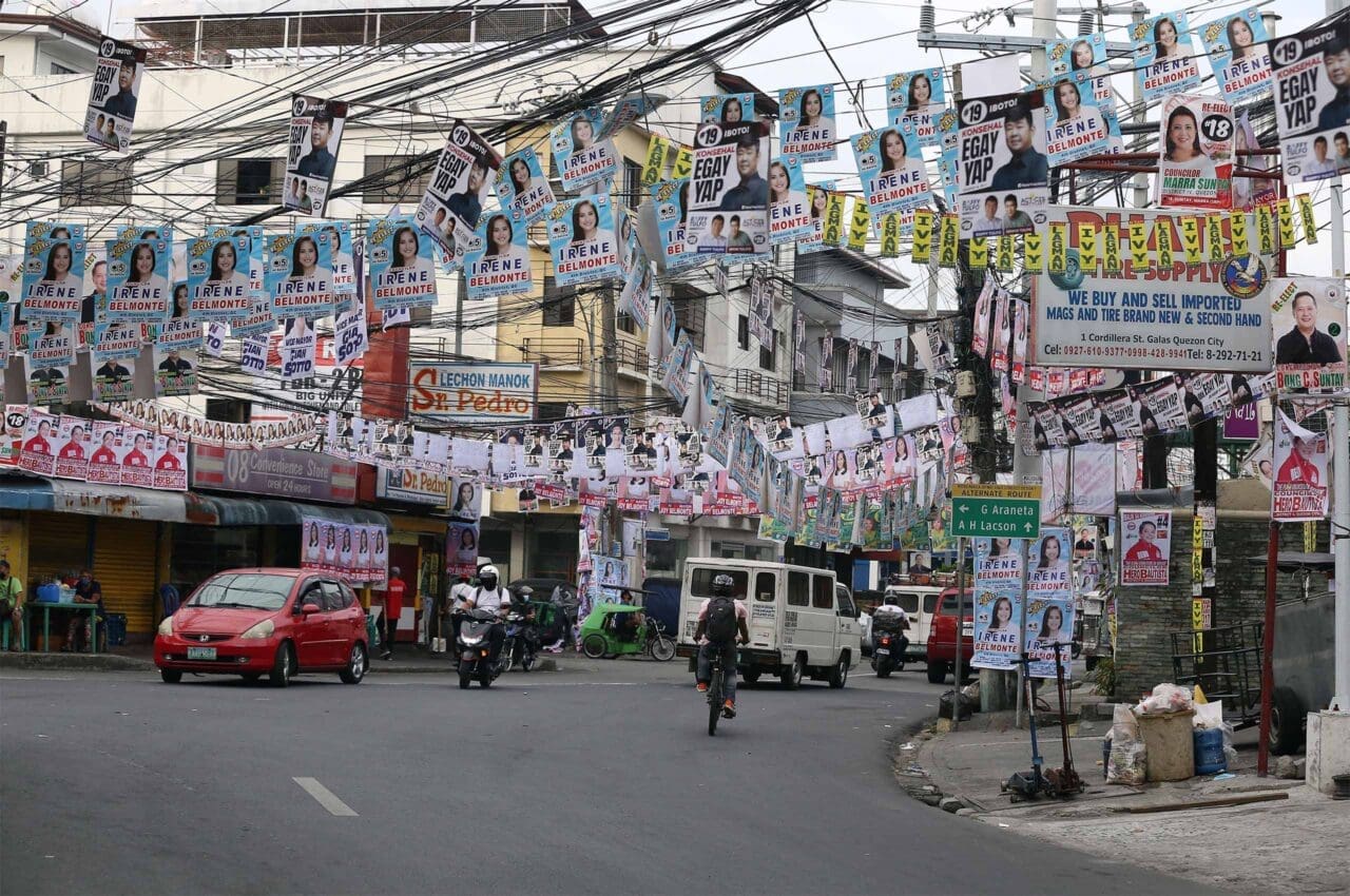 Campaign posters and tarpaulins hang from electric wires and posts at the intersection of Bayani and Cordillera Streets in Quezon City