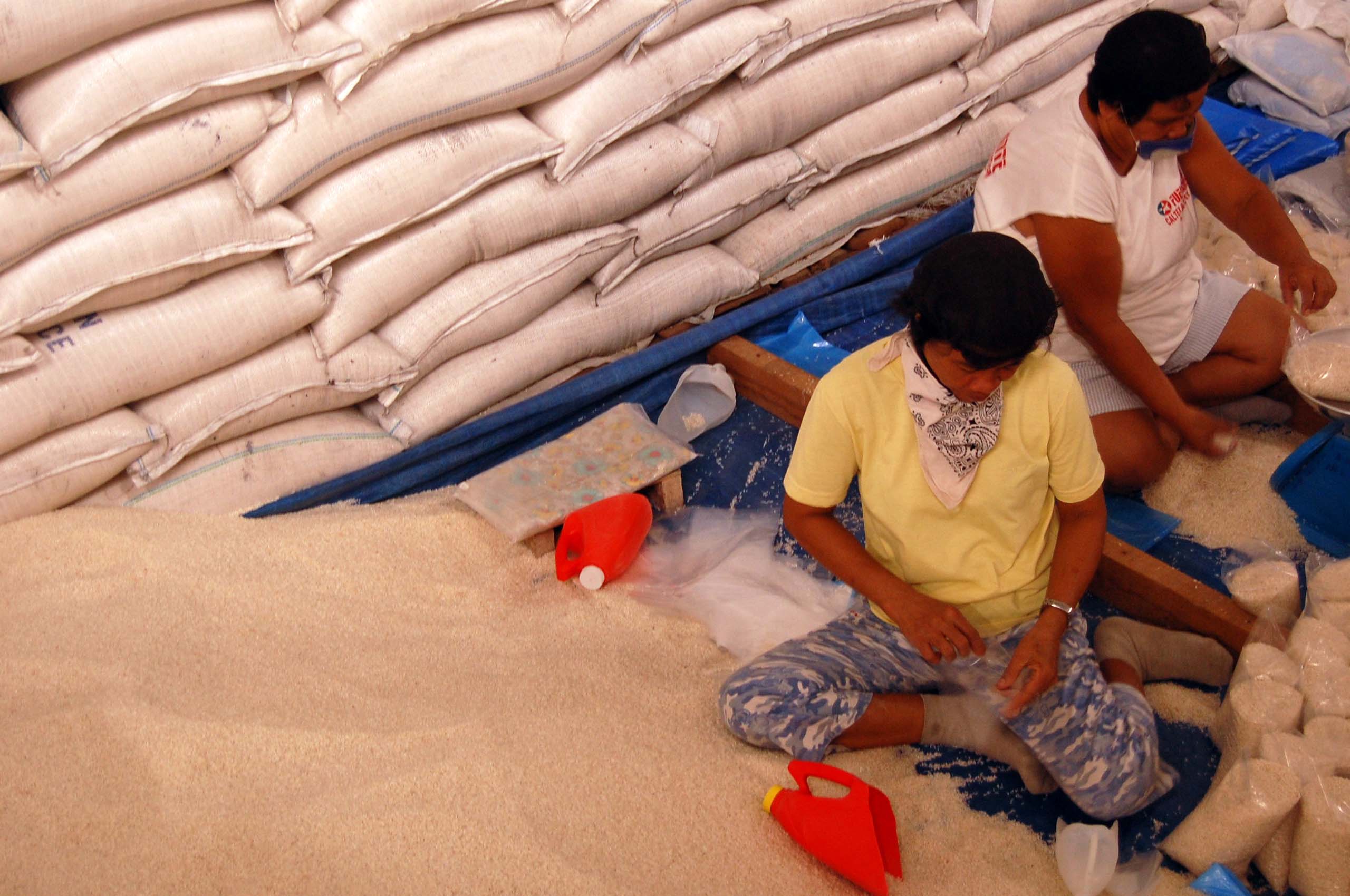 Workers rush to repack imported US rice in one of the huge NFA warehouses in Cabanatuan City