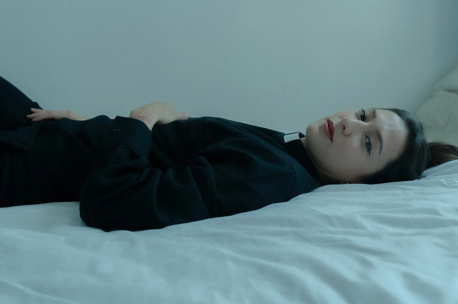 artist silke lapina dressed as a priest in bed